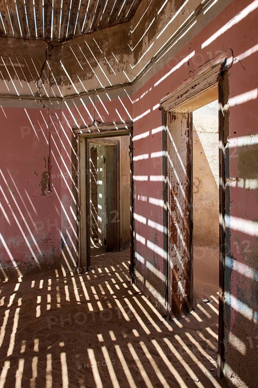 Light passing through the laths of a decaying house in the former diamond miners settlement that is slowly covered by the sand of the Namib Desert