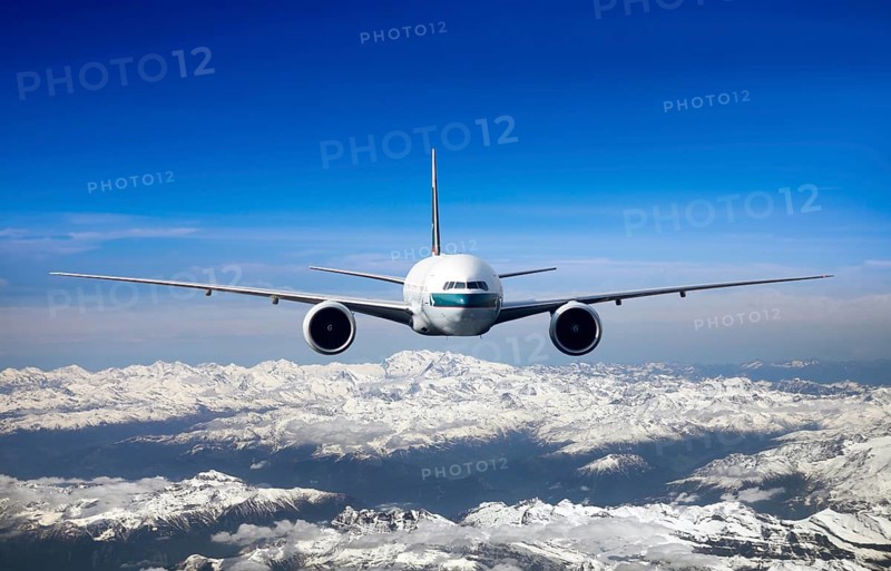 Cathay Pacific Boeing 777-367 ER in flight over mountains