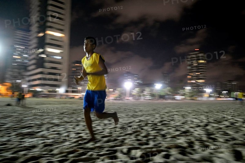 Brazilian teenager training at night on the beach for the Street Children World Cup 2014