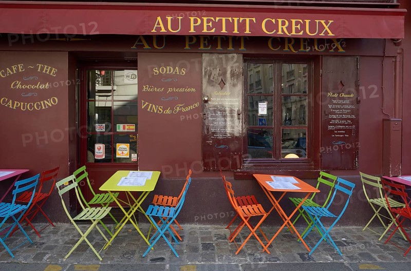 Colourful tables and chairs outside the street cafe 'Au Petit Creux'