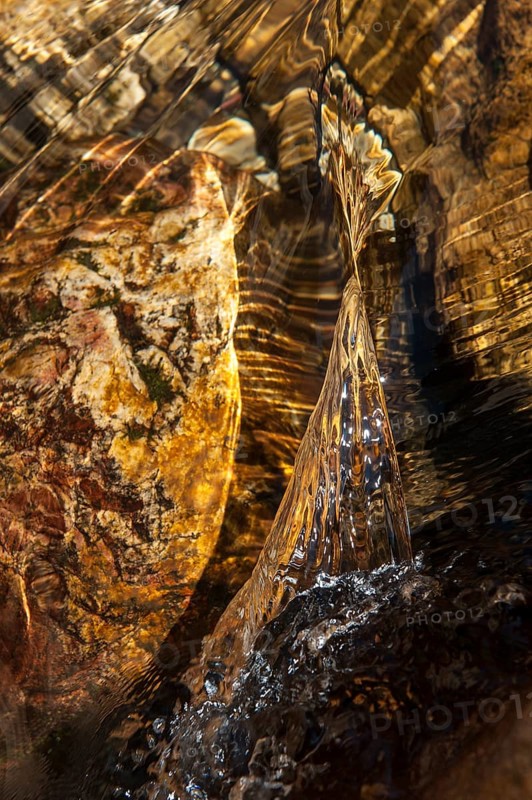 Closeup of a water stream flowing over a rock