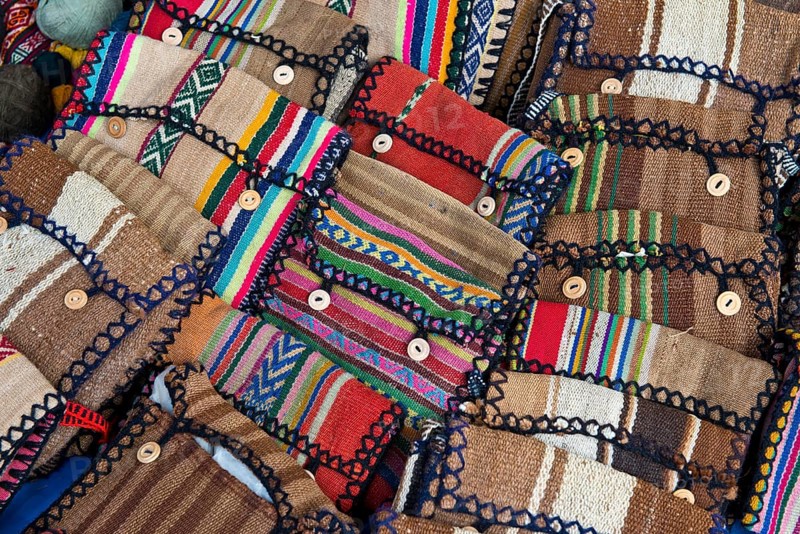 Handmade bags with the traditional patterns of the Quechua Indians are displayed for sale