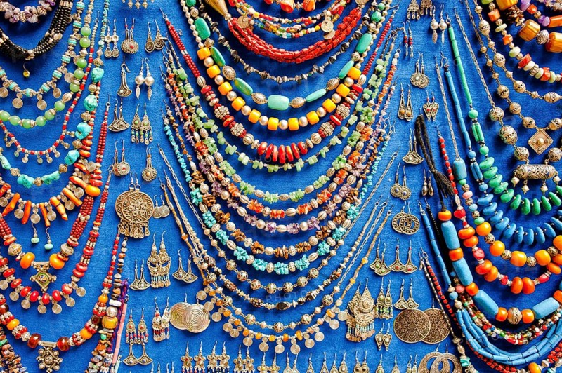 Display of various necklaces and earrings with glass beads and traditional Arab and Berber patterns
