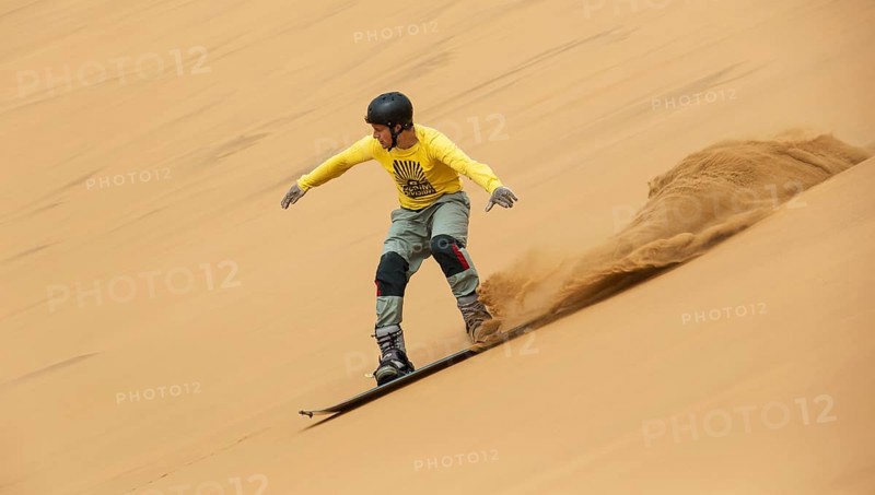 Sand boarding in the dunes of the Namib Desert