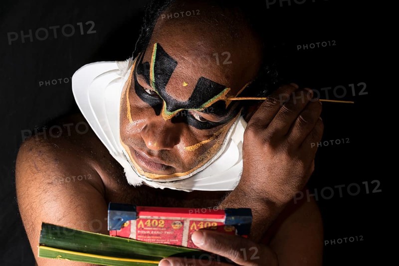 Katakali artist applying the makeup of the Shiva character