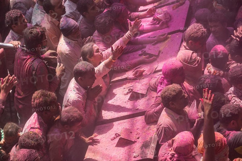 Devotees covered in coloured powder praying