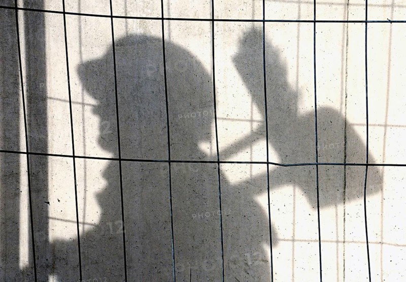 Shadow of a construction worker on a concrete wall