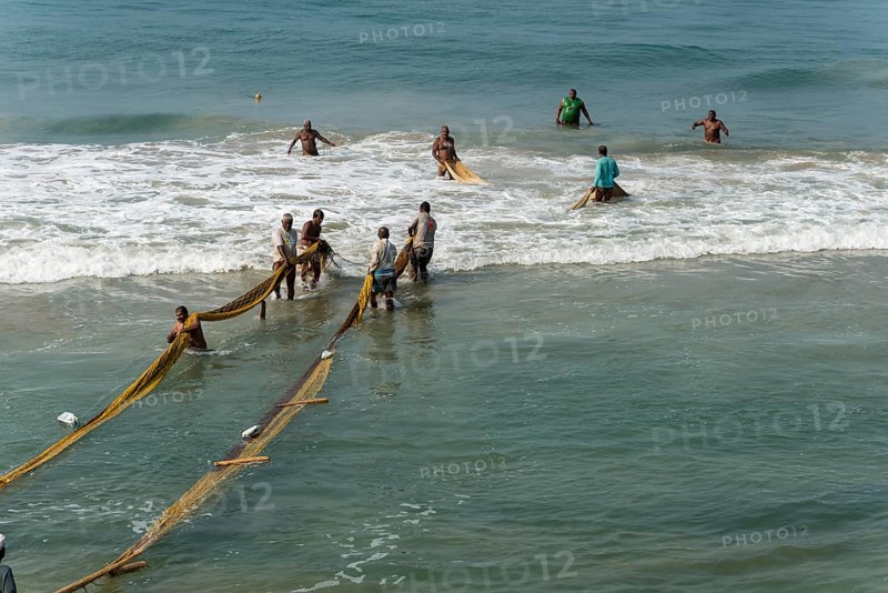 Fishermen pulling fishing nets onto the beach