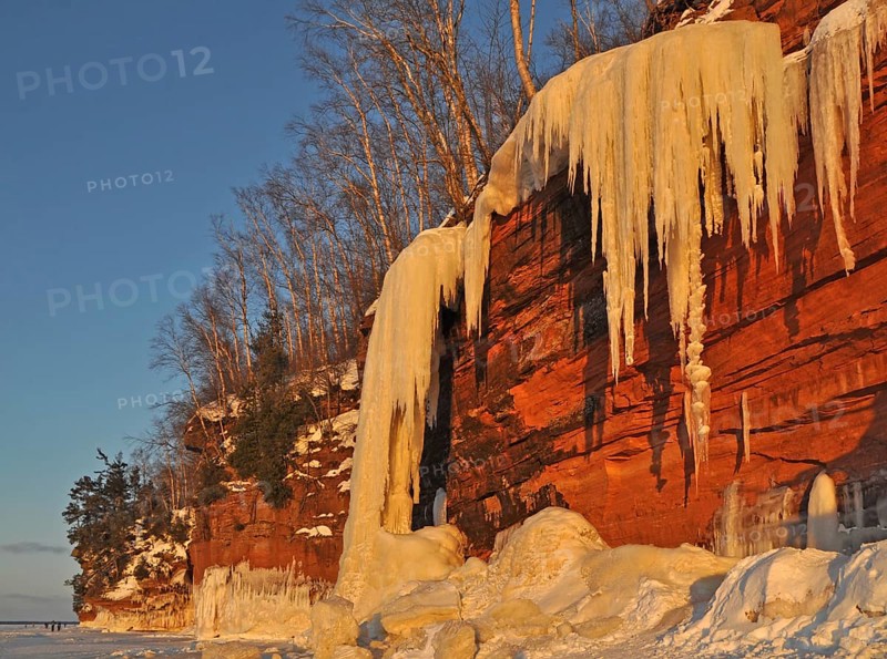 Frozen waterfall and icicles hanging from red sandstone cliff