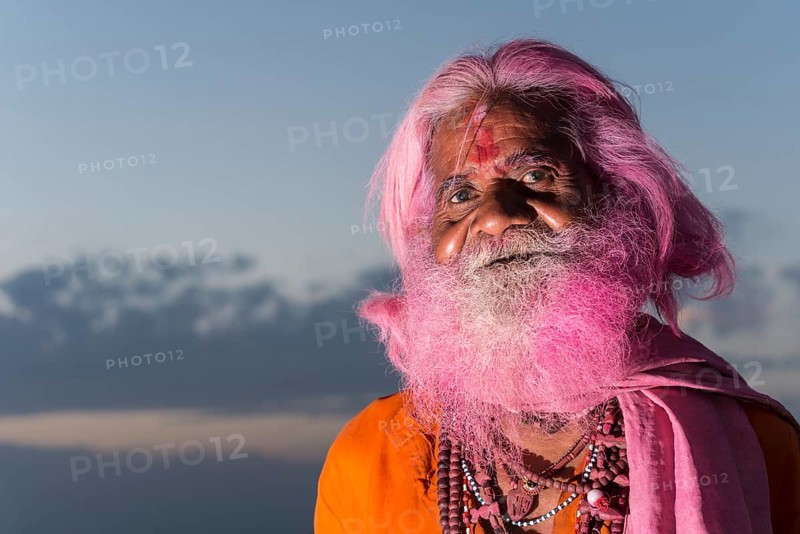 Portrait of an old man with a pink beard at the Holi festival
