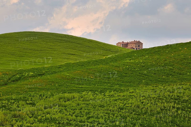 Single house between hilly fields