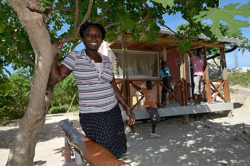 Woman standing in front of the house which she received from an aid organisation after the earthquake