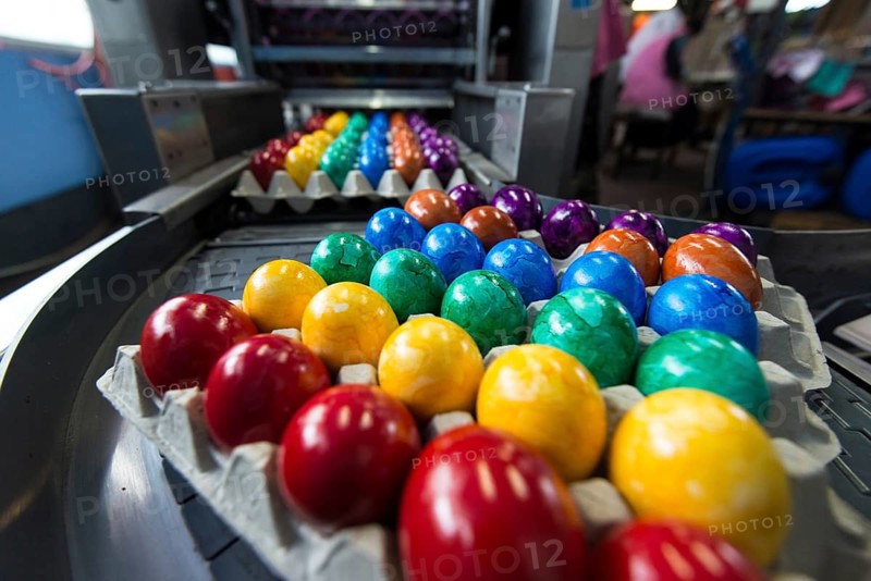 Brightly coloured Easter eggs on a conveyor belt