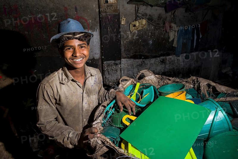 Worker sorting out plastic garbage for recycling