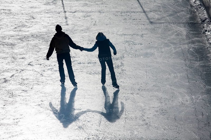 Man and woman holding hands ice skating
