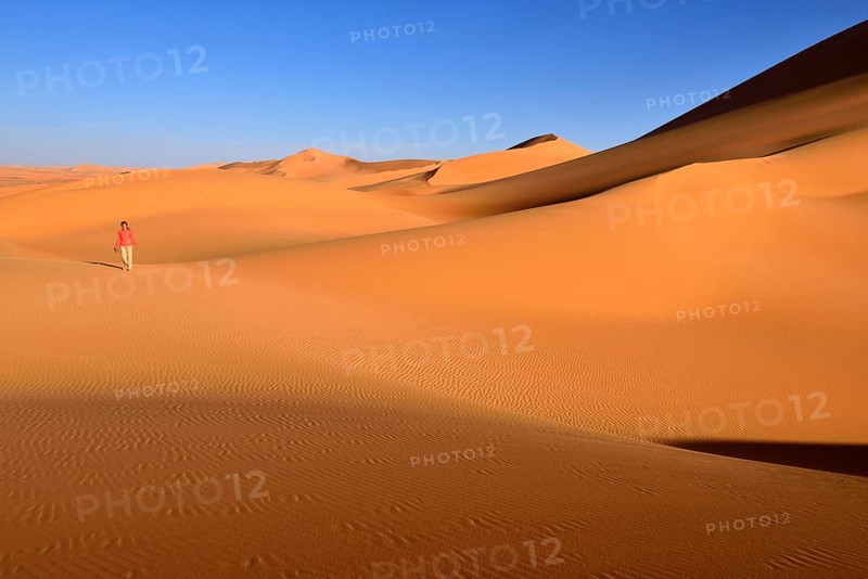 Woman walking in the dunes of In Tehak