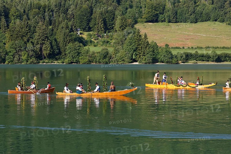 Locals wearing traditional costumes in decorated wooden Platte boats