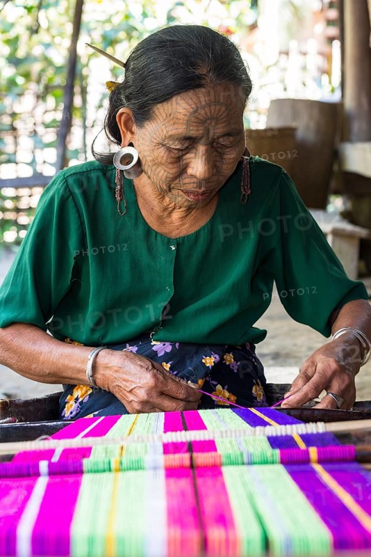 Woman with traditional facial tattoos and ear jewellery from the Chin people