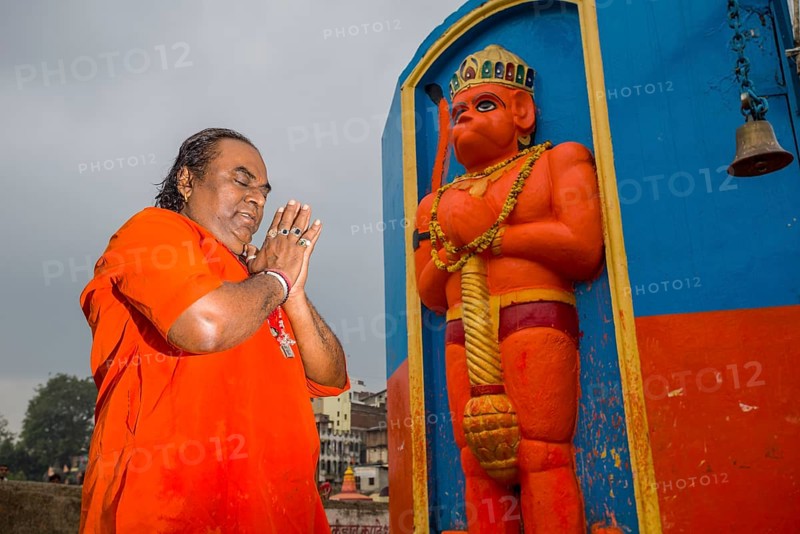 A devotee is praying in front of a Hanuman statue