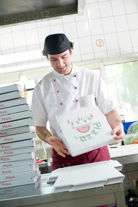 Pizza baker folding a pizza box