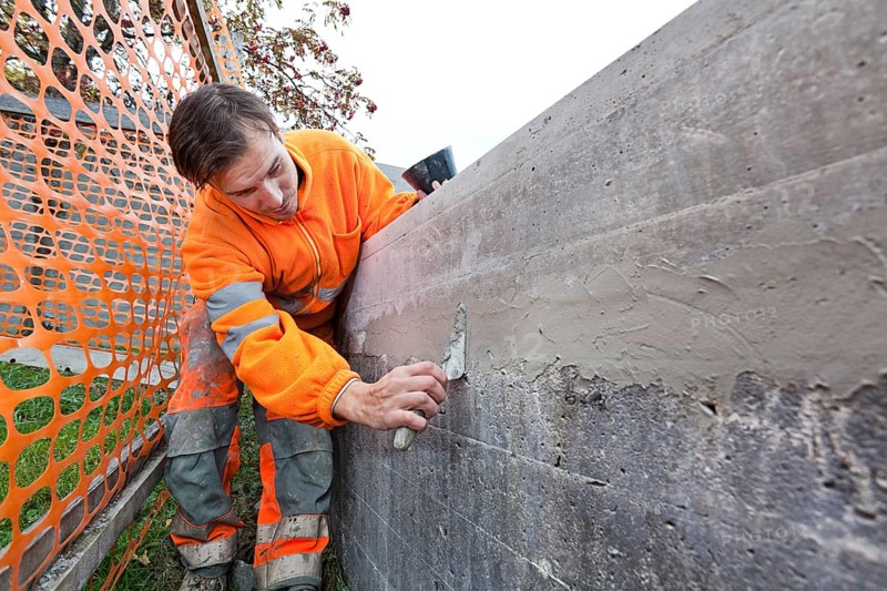 Man doing concrete restoration and construction work on the main building of the HSG University of St. Gallen