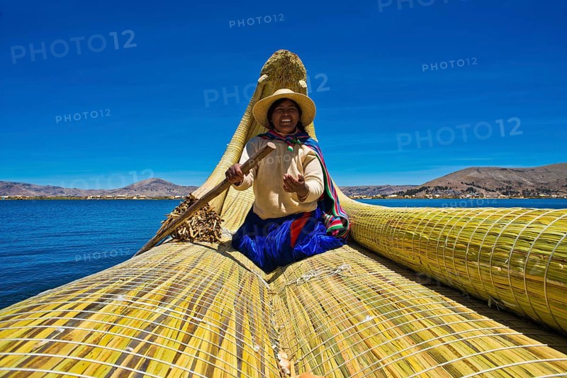 A local woman rowing a traditional boat made of totora reeds on Lake Titicaca