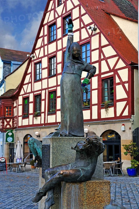 Statues wearing gloves on the Gauklerbrunnen well by artist Harro Frey
