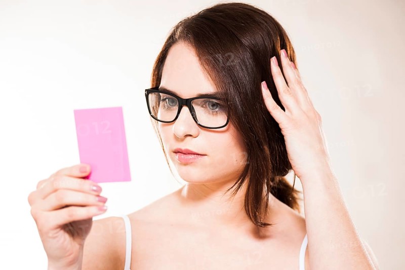 Young woman looking at herself in a cosmetic mirror