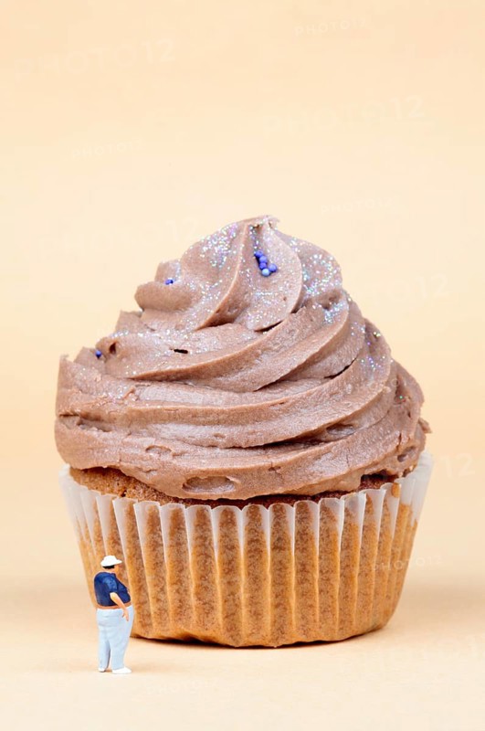 Miniature figurine standing in front of muffin