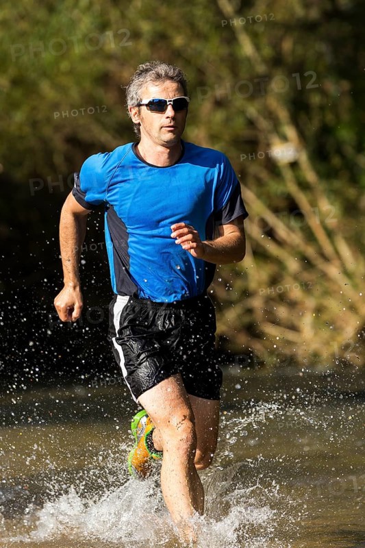 Jogger running through a stream