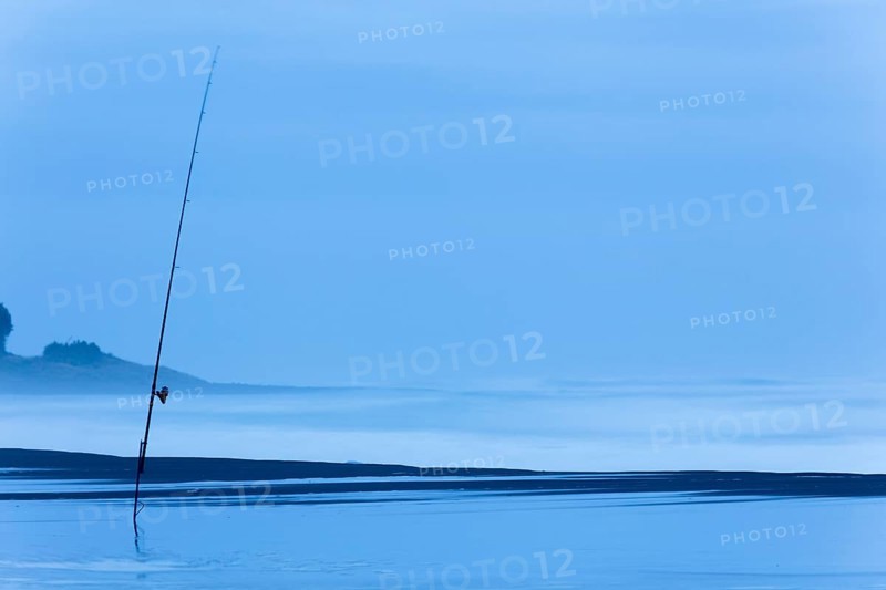 Fishing rod on the beach at dusk