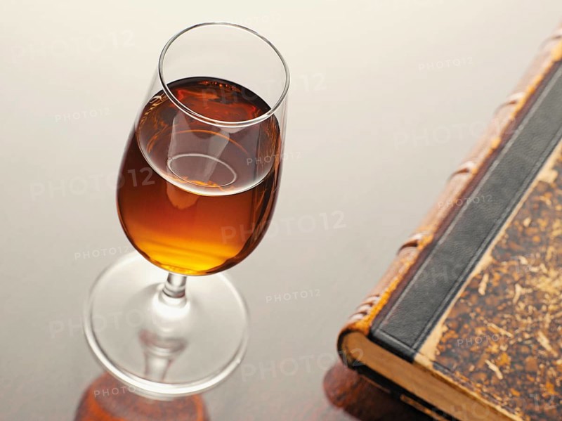 Glass of sherry beside an old book