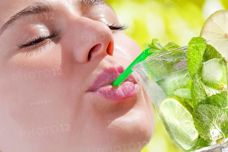 Woman drinking a Hugo cocktail with lime and mint