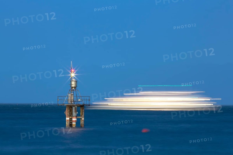 Evening mood with a with moving ship at the Hoernle Lighthouse