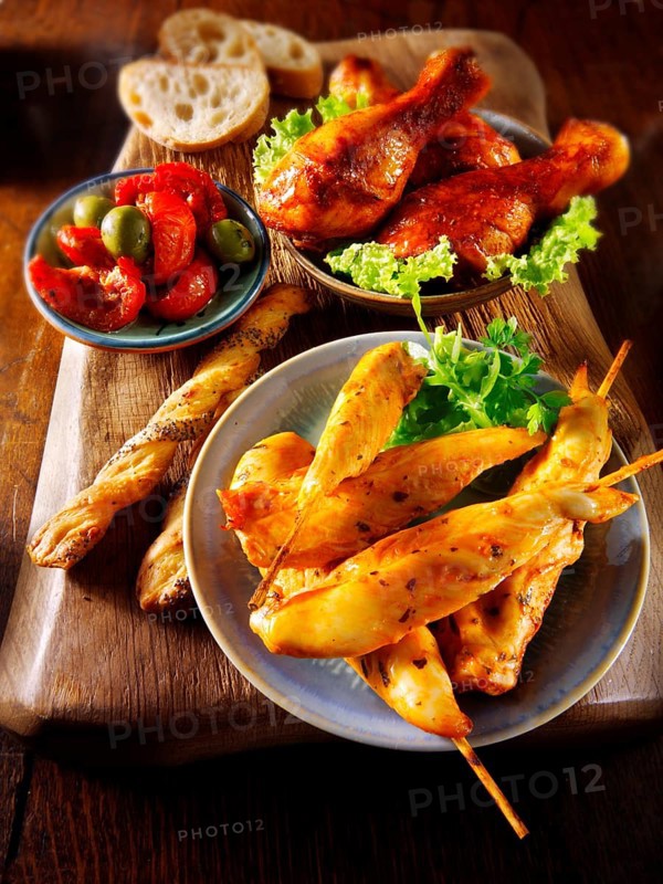 Party buffet with chicken satay and grilled chicken legs