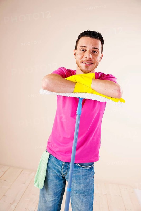 Smiling man leaning on a mop
