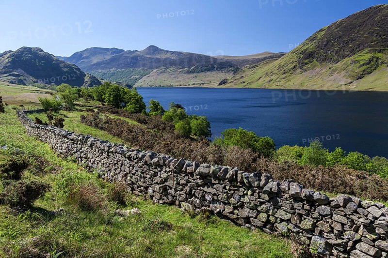 View over an old English stone wall towards the blue lake of Crummock Water