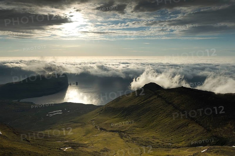 Coastal landscape with Kollur Mountain and the sea stacks of Risin and Kellingin in the evening light
