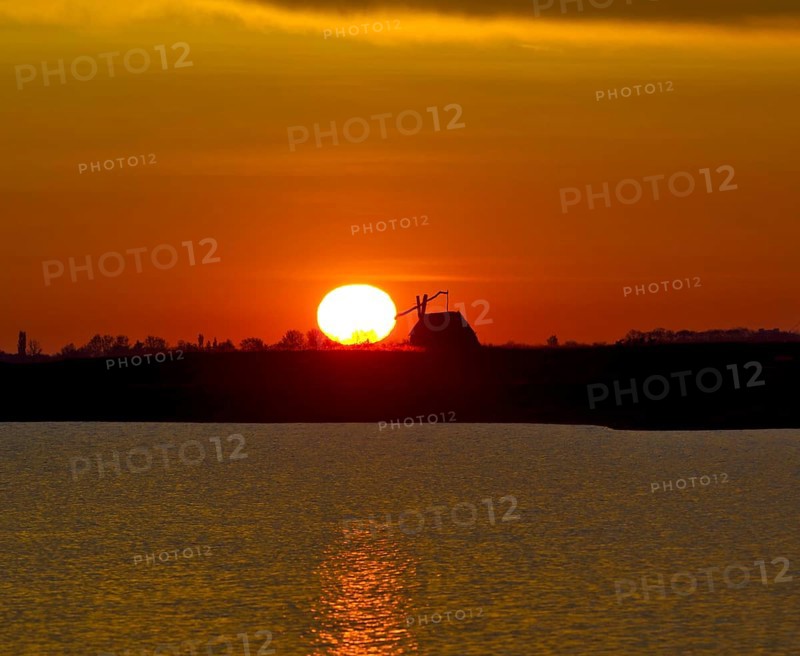 Sunrise with drawing well at Darscho-Lacke or Warmsee Lake