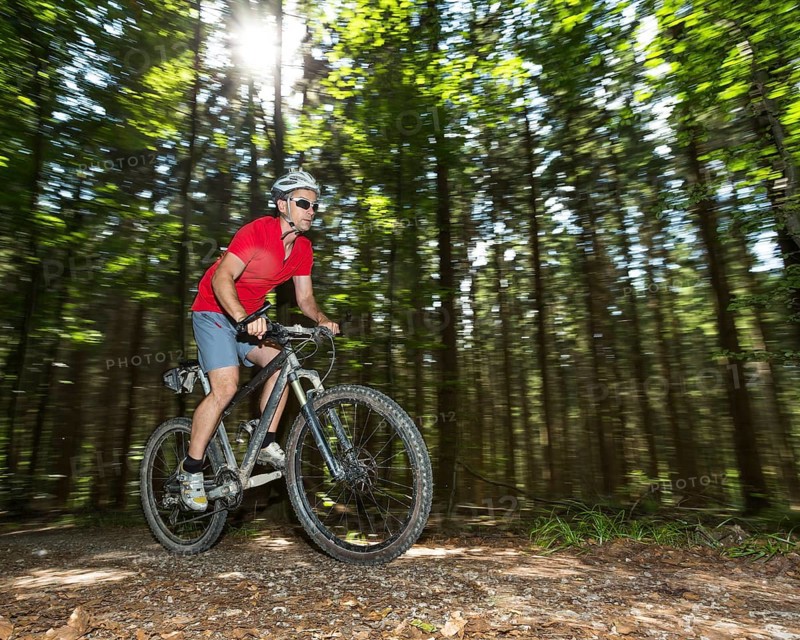 Cyclist on a mountainbike riding through a forest