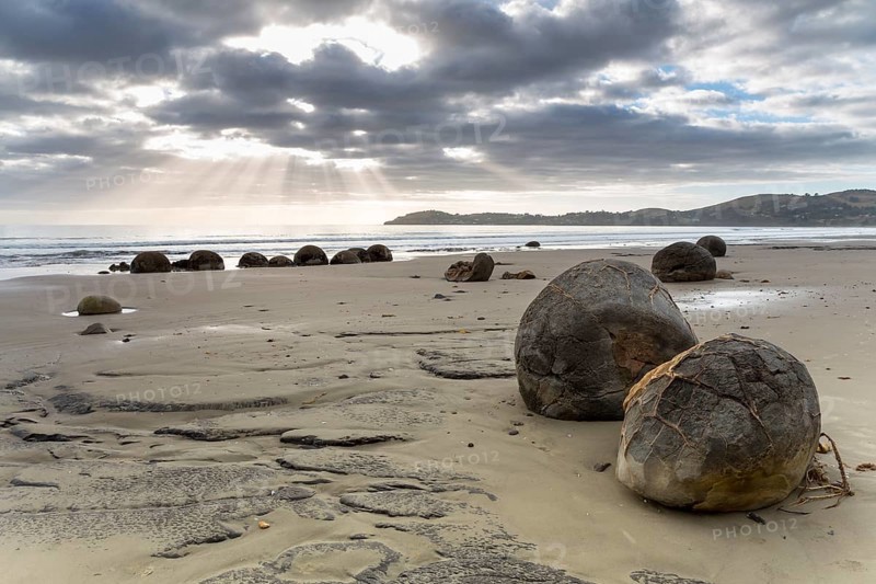 Moeraki Boulders on the beach with sunbeams in the early morning
