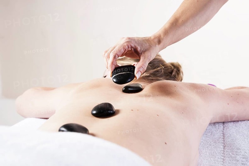 Young woman being treated with hot stones