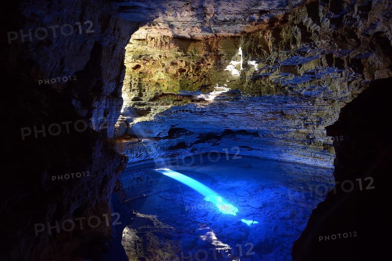The colorful cave Poco Encantado with rays of light