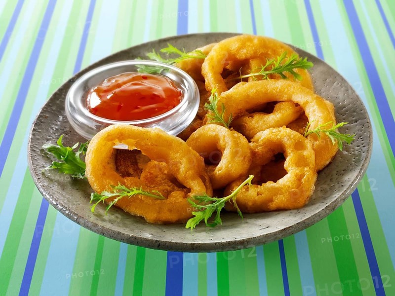 Deep fried breaded onion rings with chili sauce and salad