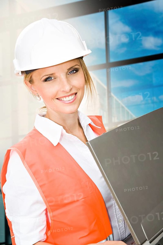 Young female constructor in front of a new building