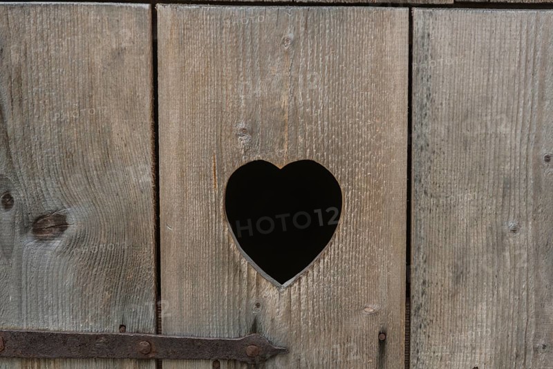 Heart-shaped cut-out in the wooden door of a toilet