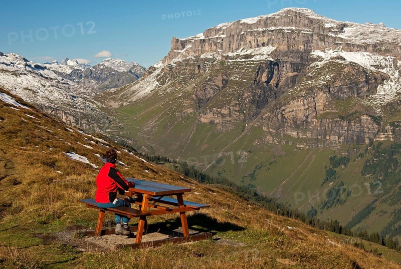 Walker looking from a rest area high above the Urnerboden high valley on the Klausen Pass