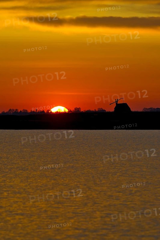 Sunrise with drawing well at Darscho-Lacke or Warmsee Lake