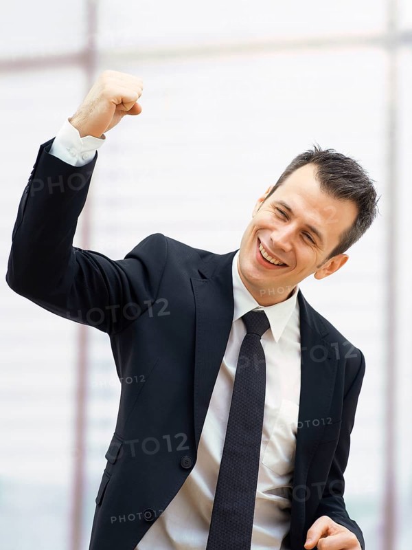 Businessman in an office cheering with a clenched fist