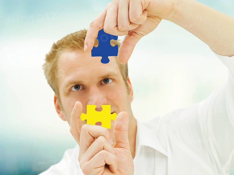 Man putting pieces of a jigsaw puzzle together